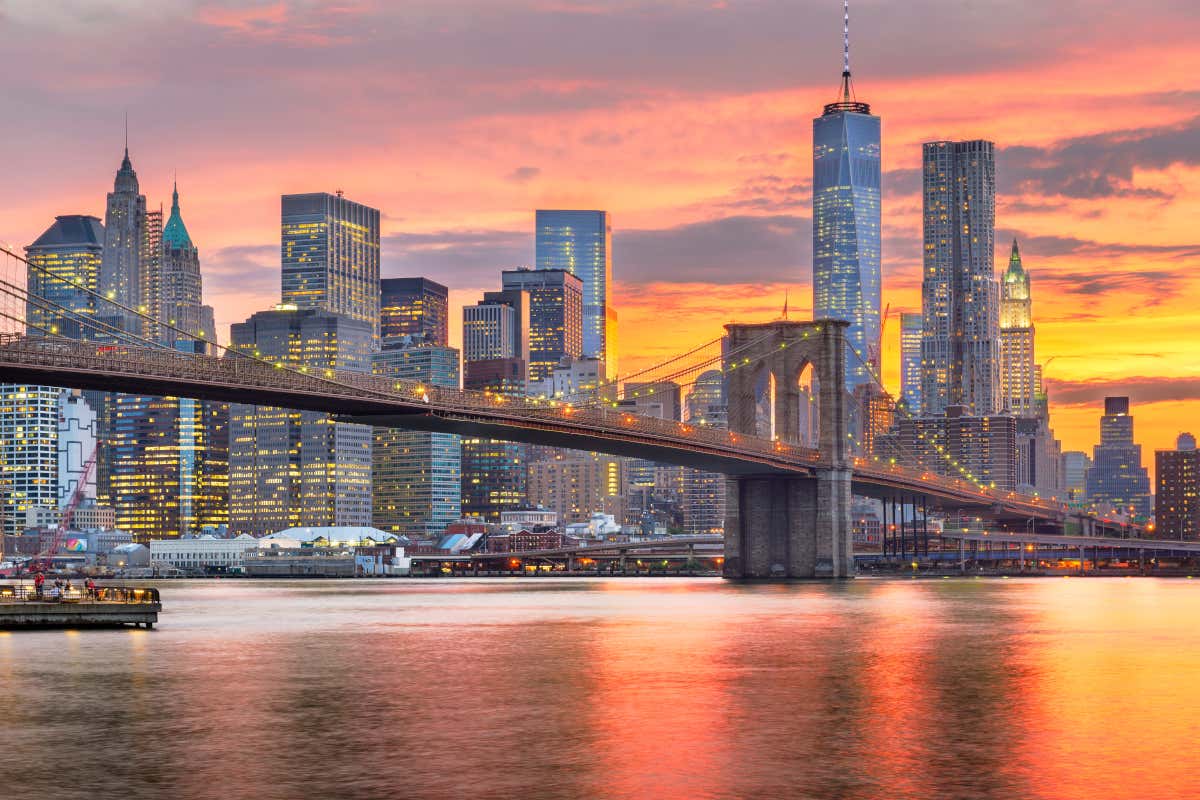 Vue sur le pont de Brooklyn à la tombée de la nuit avec le ciel rose orangé