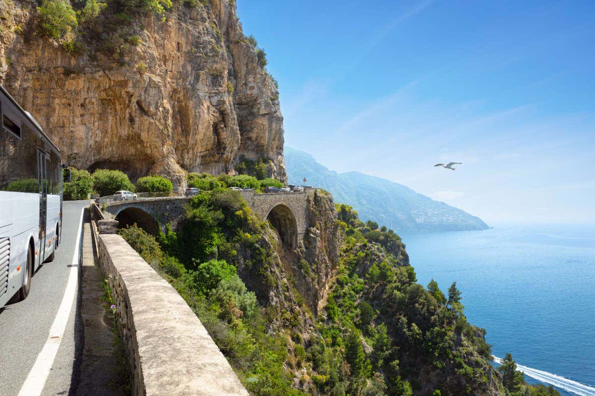 Un autobús por una serpenteante carretera junto a un acantilado