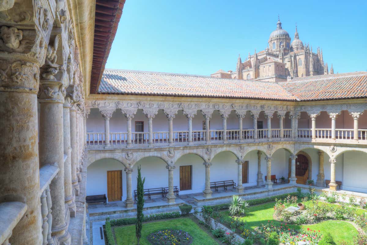 Claustro de un convento, con una catedral de fondo