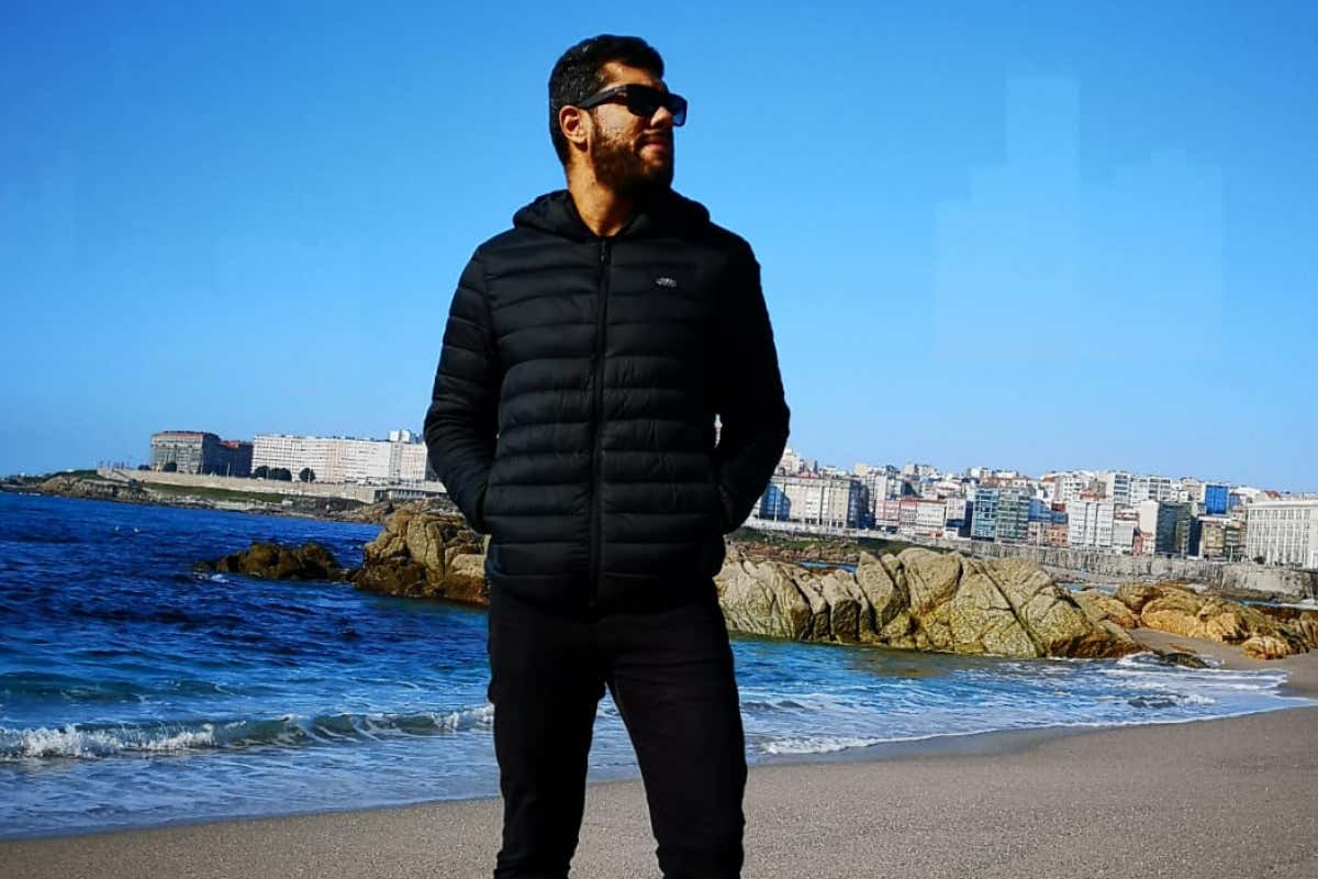 Um homem com óculos escuros posando na praia de Riazor, em La Coruña, no inverno de 2018