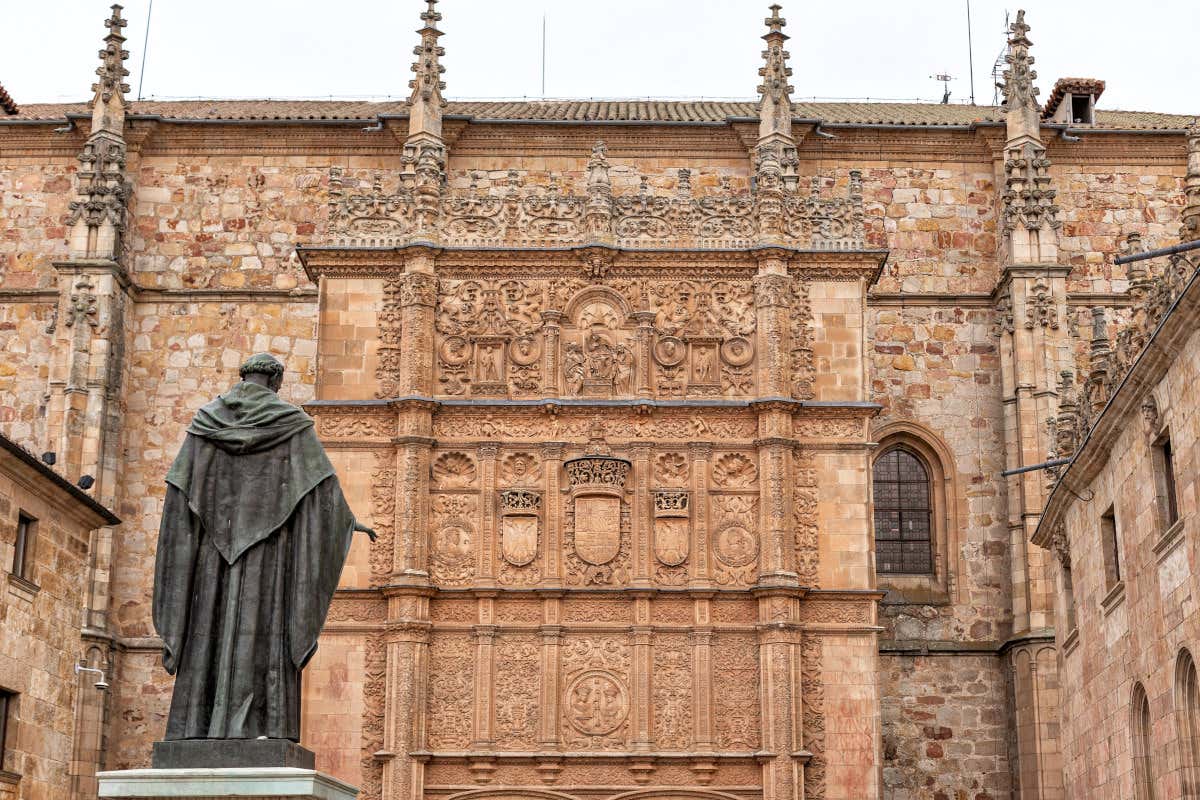 Escultura de fray Luis de León frente a la fachada plateresca de las Escuelas Mayores de la Universidad de Salamanca