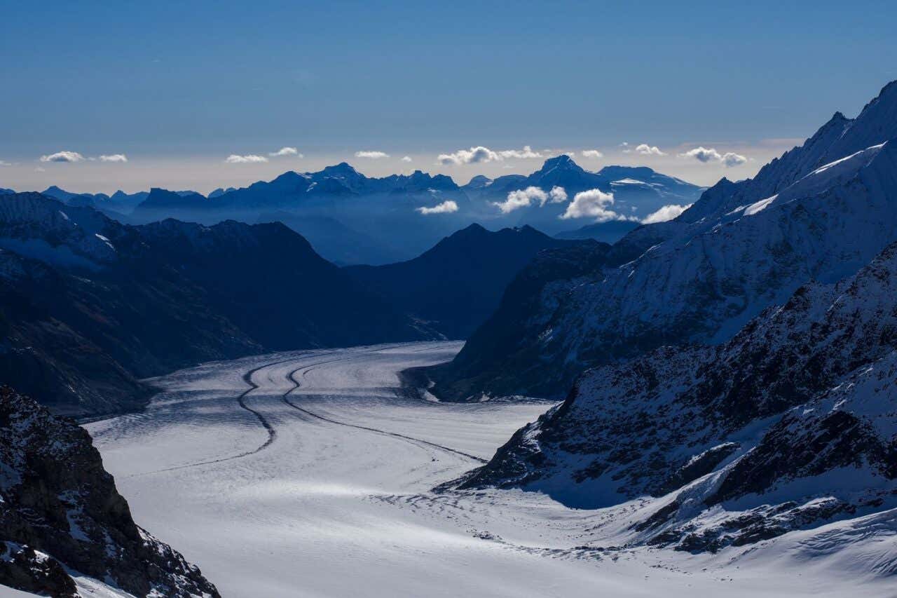 Un glaciar rodeado de un valle rocoso