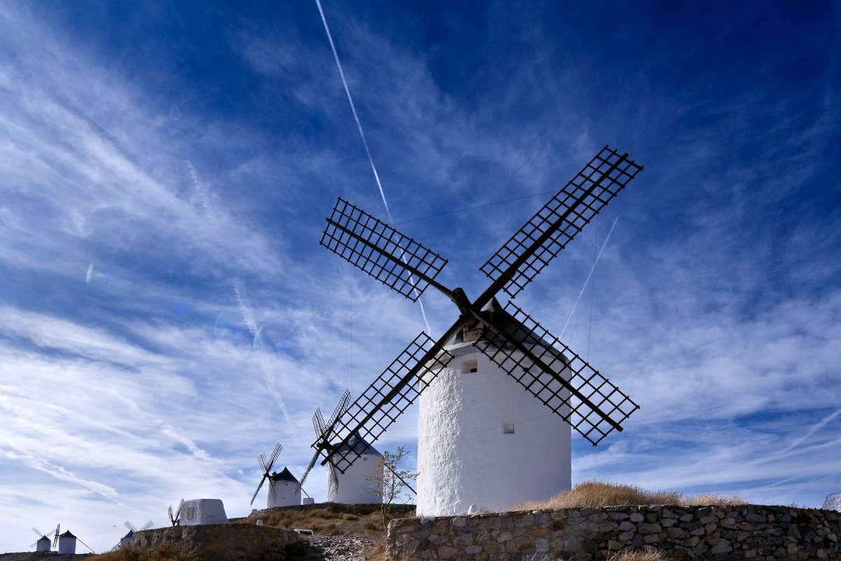 Molinos de viendo en un paisaje manchego con el cielo azul al fonto