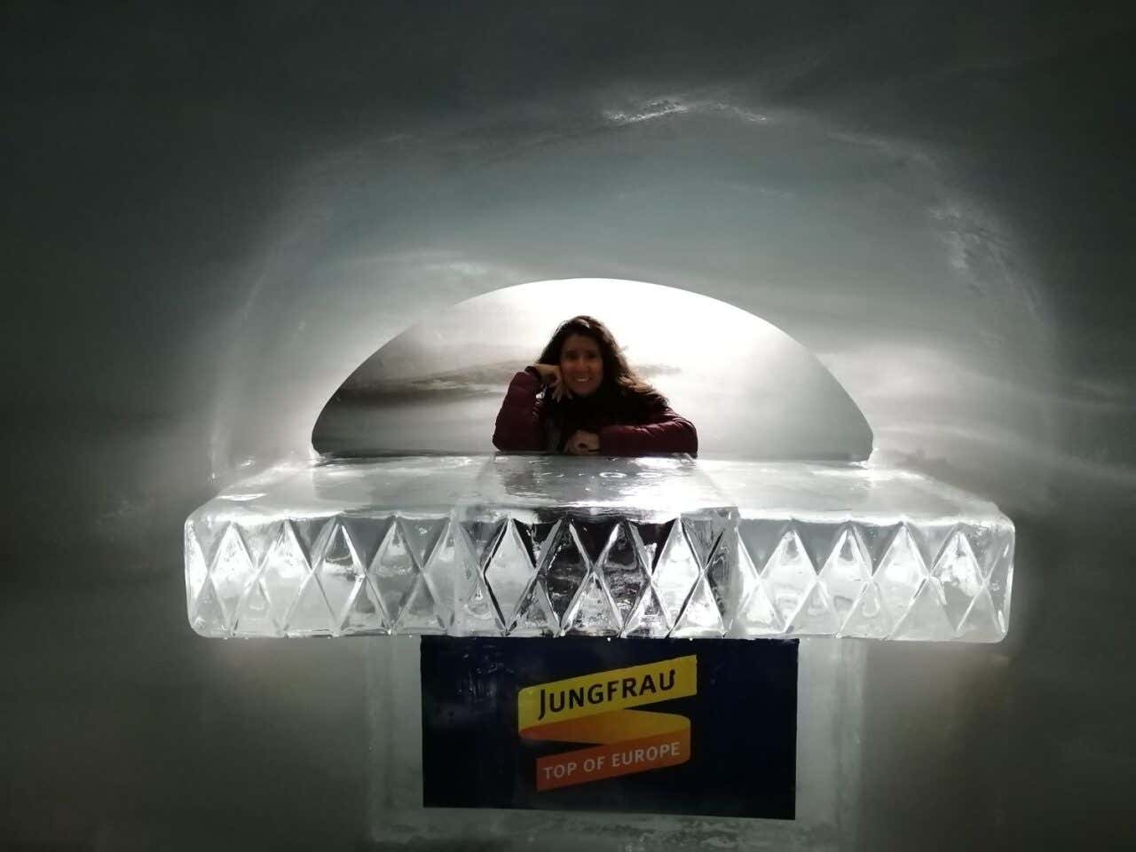 Una mujer sonríe en una estructura de hielo en un túnel