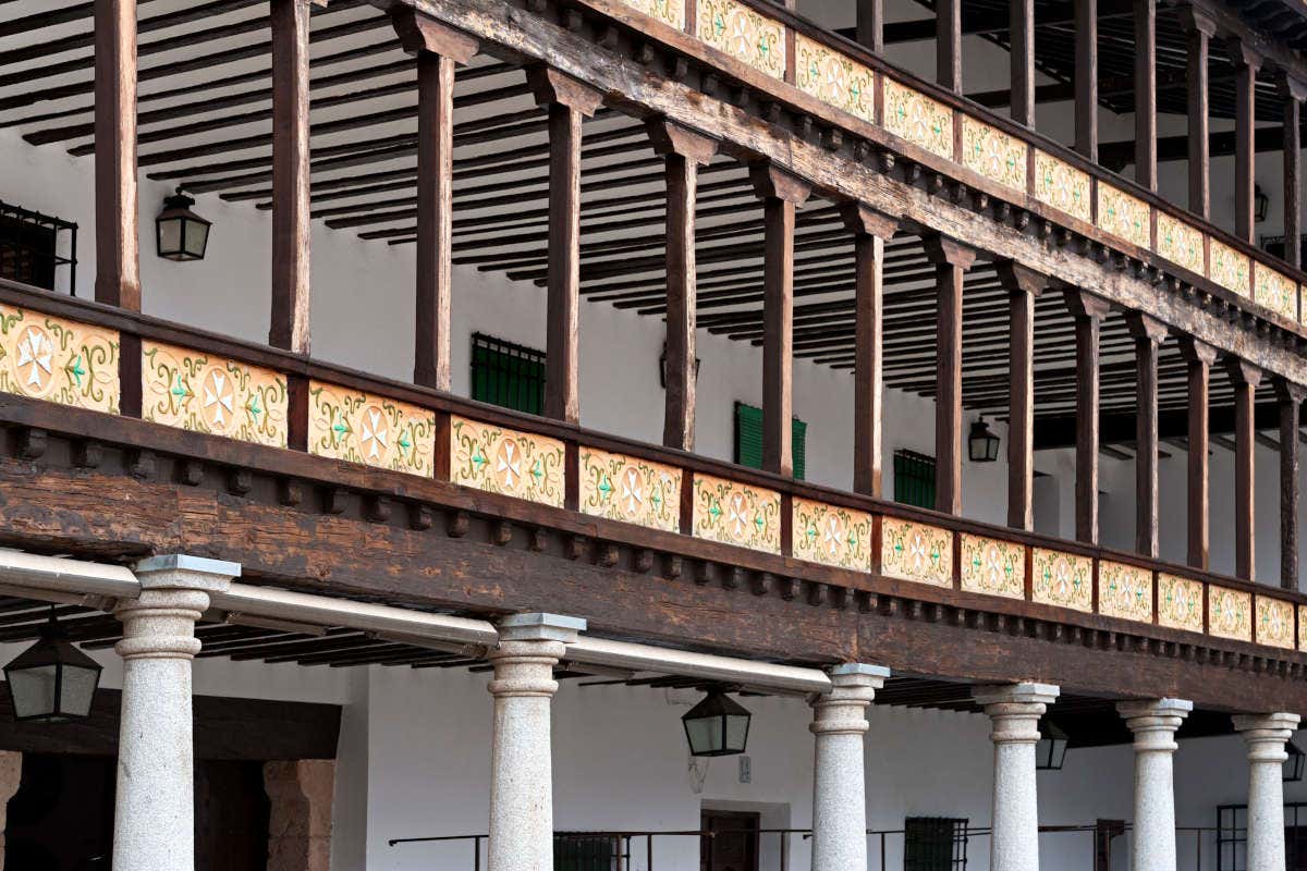 Arcadas de madera sobre un edificio blanco con pilares