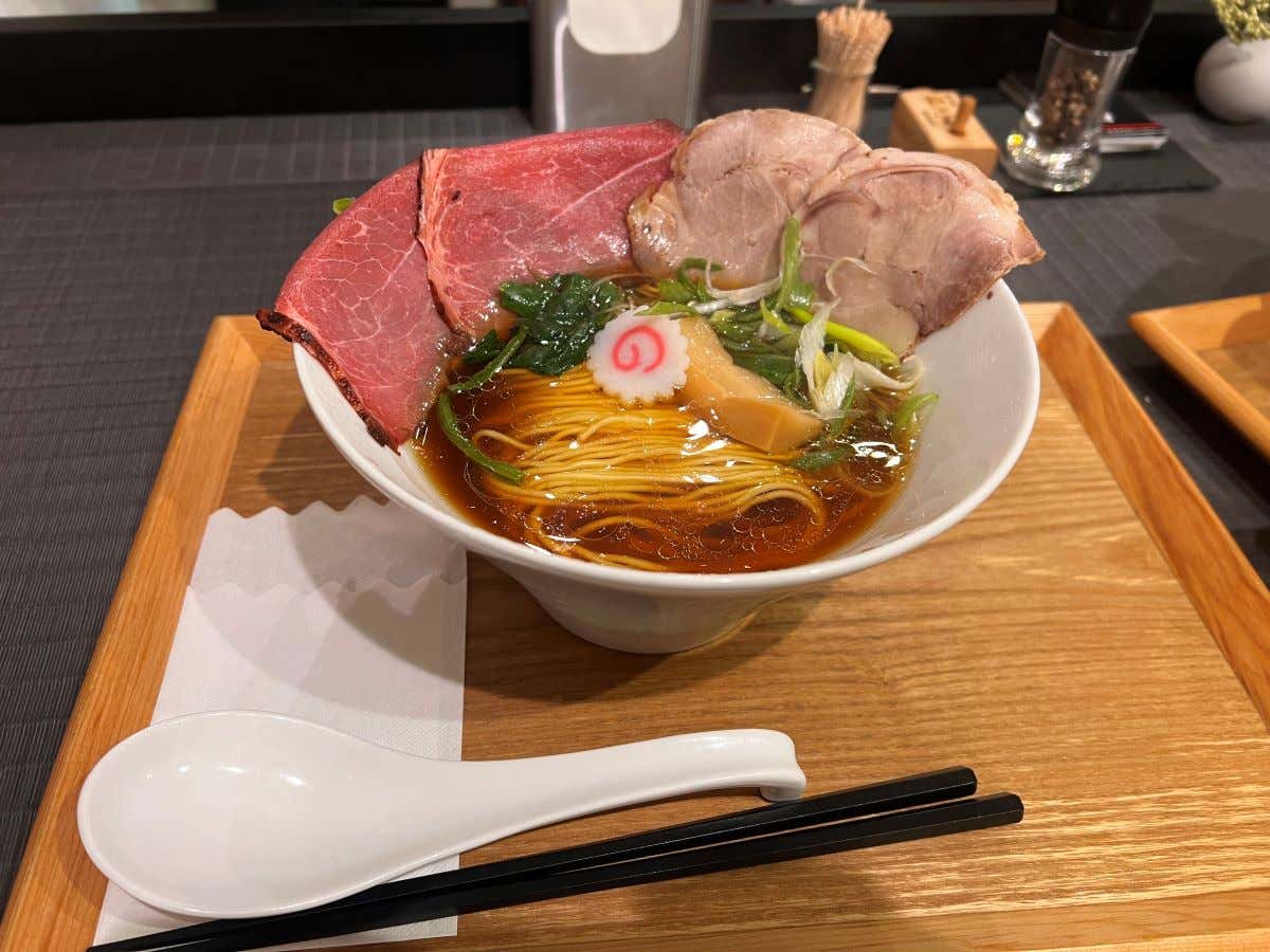 Detalle de un plato con ramen sobre una bandeja de madera, un plato que comer en Japón