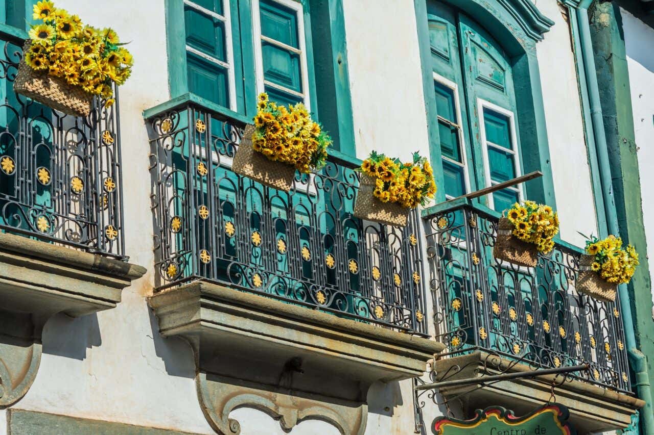 Varandas com janelas verdes e girassóis nos casarões de Mariana