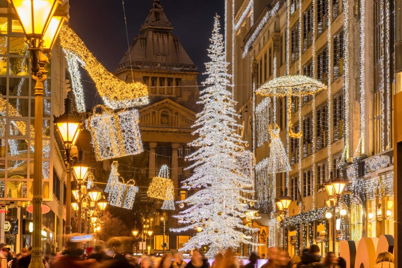 Il centro storico di Budapest illuminato a Festa con le luminarie natalizie e con un albero ricoperto di luci bianche al centro di una piazza