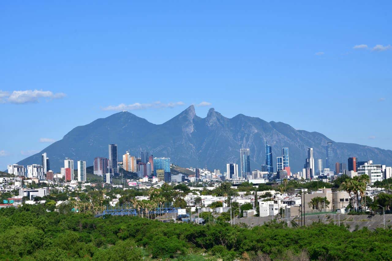 Cerro de la Silla as seen from the city, with a slightly cloudy blue sky in the background.
