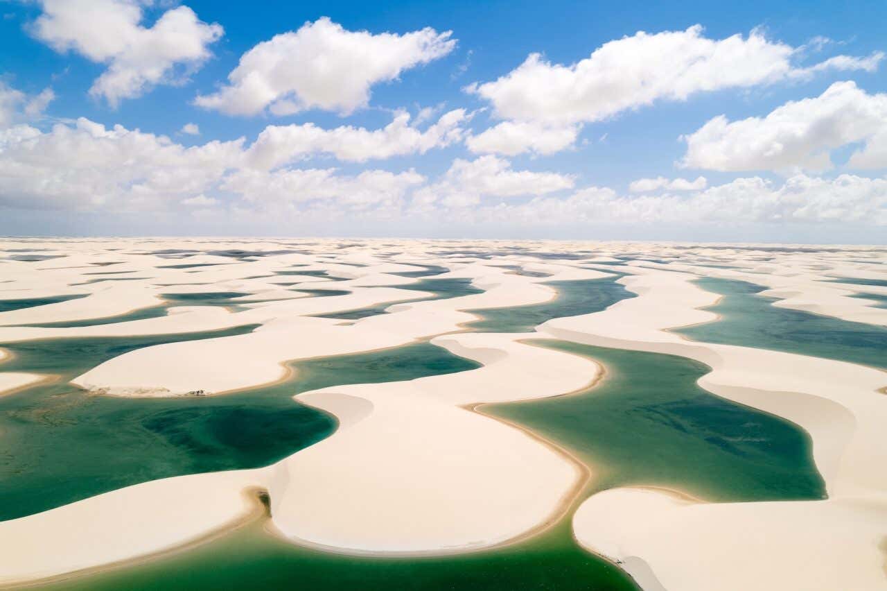 Paisagem icônica dos Lençóis Maranhenses com as dunas preenchidas com águas verde-esmeralda