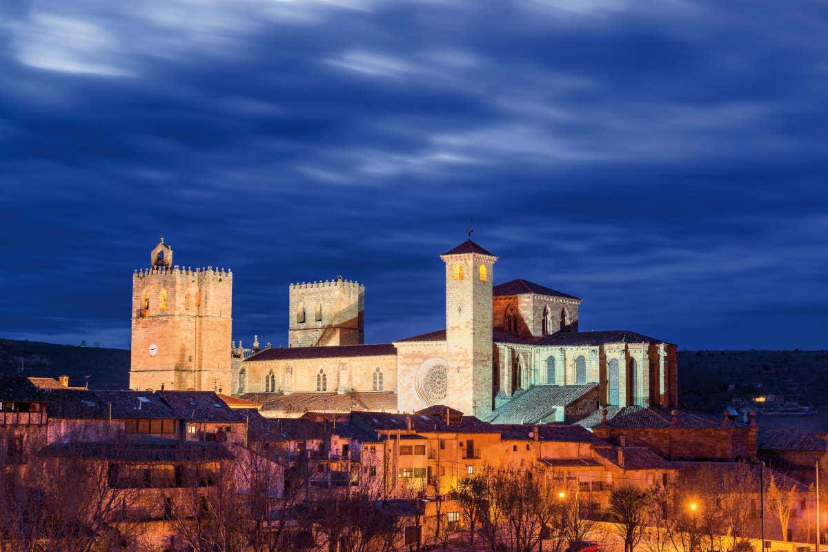 Panorámica de una catedral románica con torres iluminada de noche