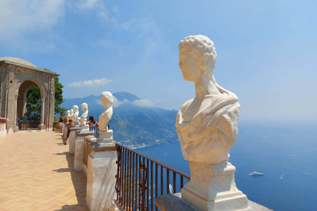 Estaturas de mármol blanco en un mirador con vistas al mar azul