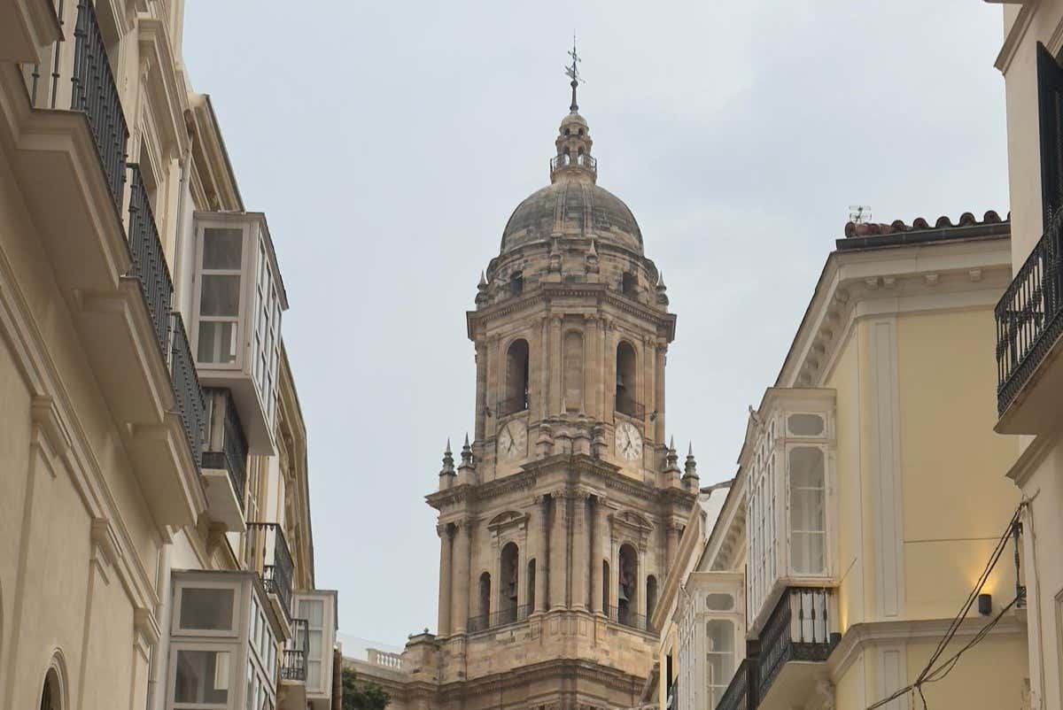 The Cathedral of Málaga among buildings on a cloudy day