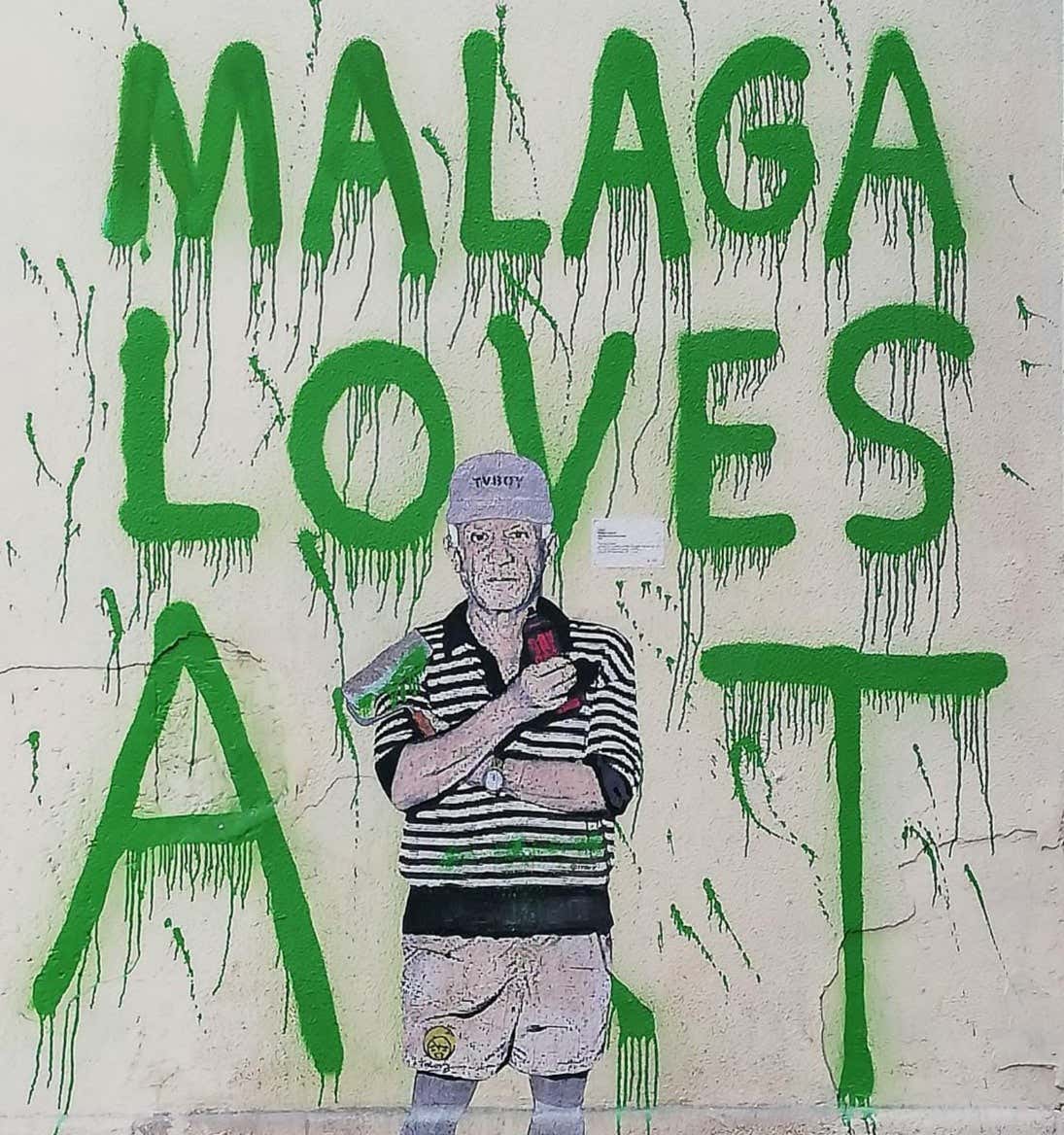 A green graffiti that says Málaga Loves Art with a painted Pablo Picasso