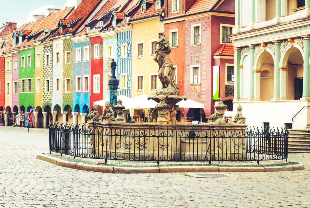 Detalle de la Fuente de Proserpina, en Poznań, con casitas de colores de fondo