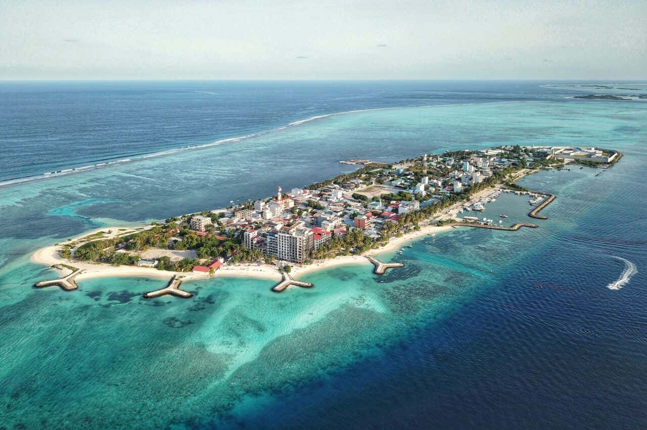 Vista aérea da ilha Maafushi rodeada de águas azul turquesa