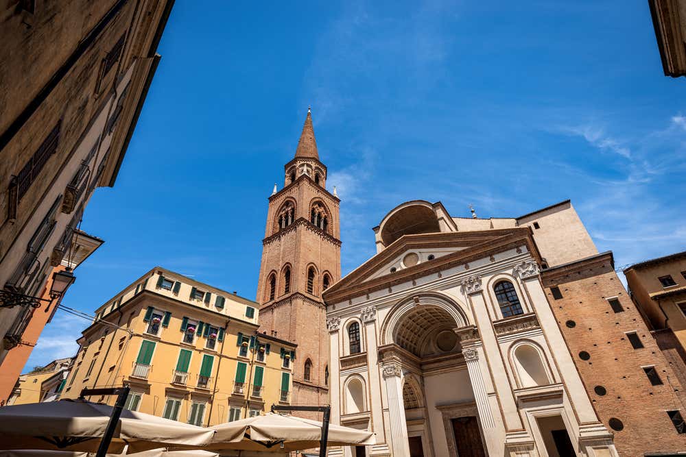 Cattedrale di Mantova con il suo campanile in mattoni rossi e la facciata rinascimentale in marmo bianco sotto un cielo azzurro