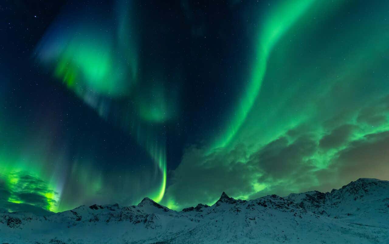The Northern Lights in Tromsø seen from below at night.