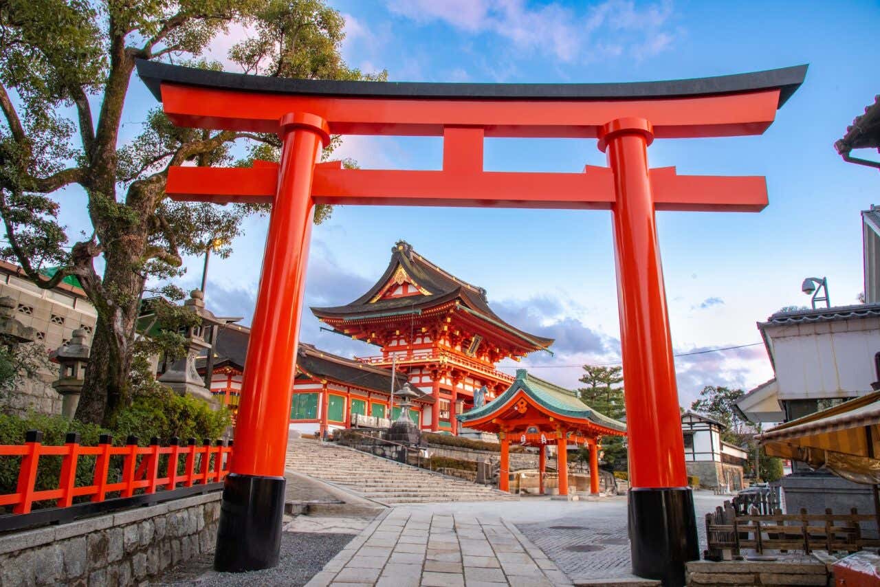 Mirante do Fushimi Inari Taisha, com edifícios tradicionais japoneses e um tori à frente