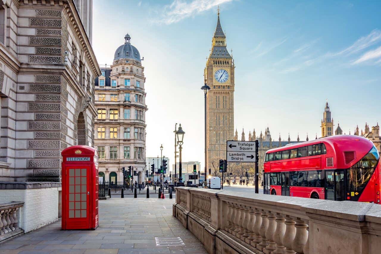 Cabine telefônica vermelha e ônibus de dois andares na Praça do Parlamento e na torre do Big Ben