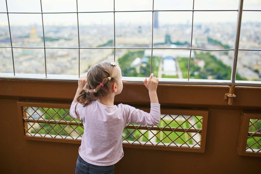 Una bambina osserva il paesaggio degli Champs-Élysées da uno dei punti panoramici della Torre Eiffel
