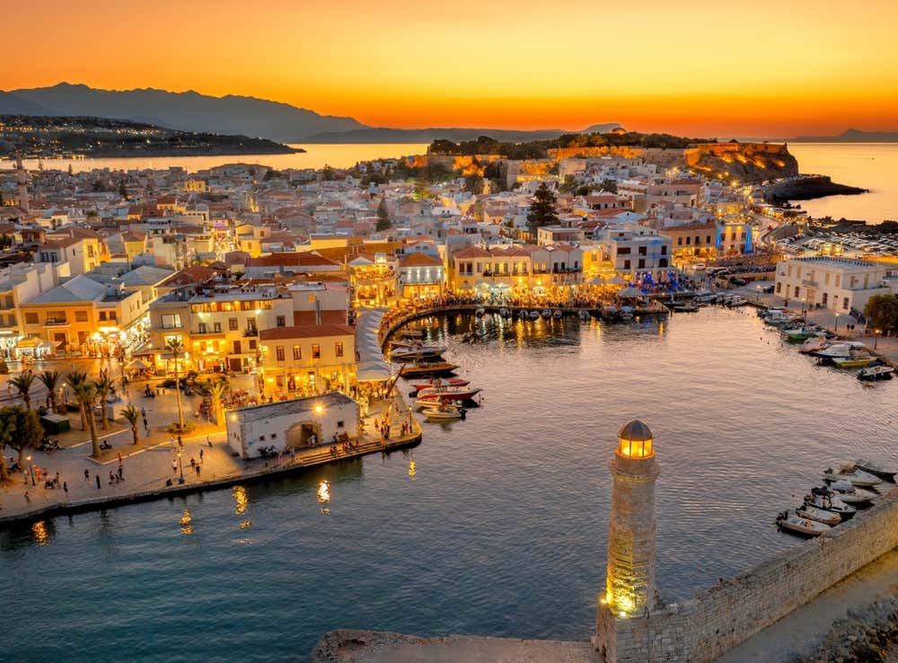 Rethymno, cittadina dell'isola di Creta, e il suo porto con i caldi colori del tramonto e il mare sullo sfondo.