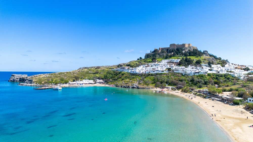 Vista su Lindos, piccolo villaggio dai piccoli edifici bianchi e la sua Acropoli in cima alla collina, su Rodi, isola greca dell'Egeo