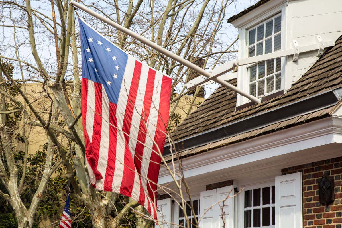 Exteriores de Betsy Ross House con una bandera norteamericana y varios árboles sin hojas alrededor