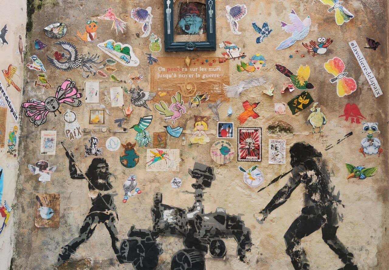 Mur street art rempli de collages et de pochoirs