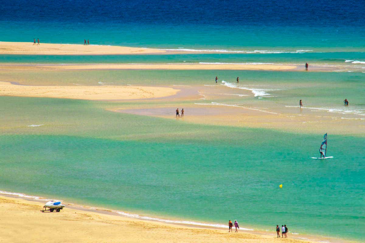 Vistas aéreas de una playa con gente haciendo kitesurf
