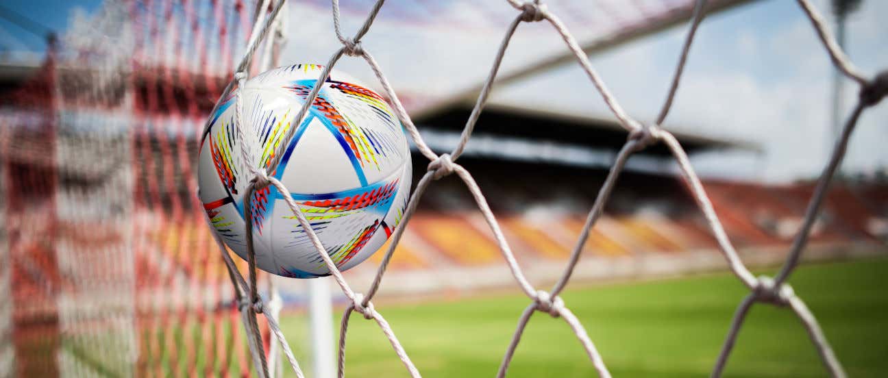 Un balón lanzado en una portería en el interior de un estadio de fútbol