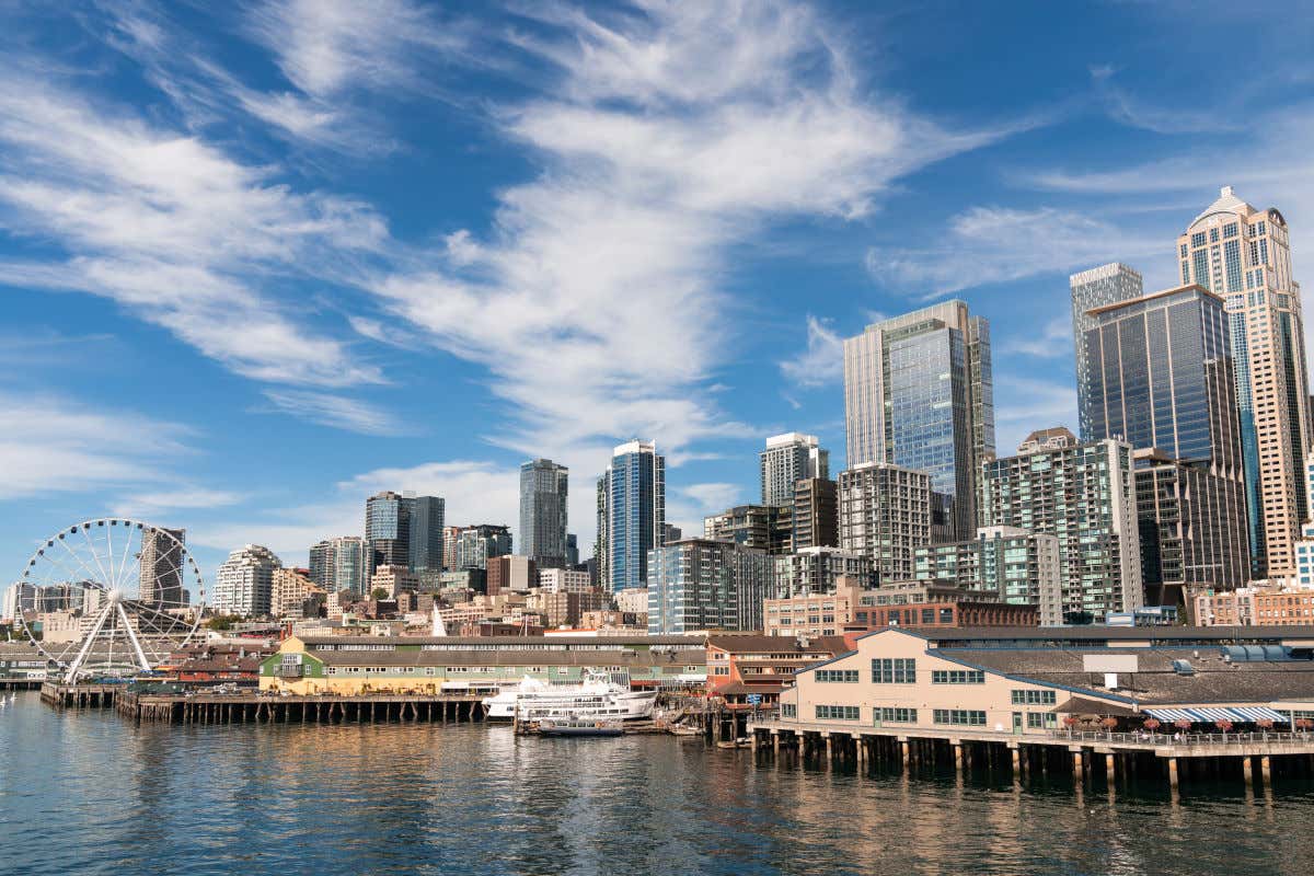 Distrito financiero de Seattle frente al mar con varios rascacielos, barcos y una noria