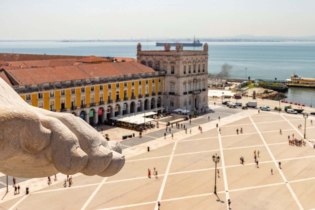 Detalhe de um pé de uma das estátuas do topo do Mirante da Rua Augusta, de onde se pode ver a Praça do Comércio