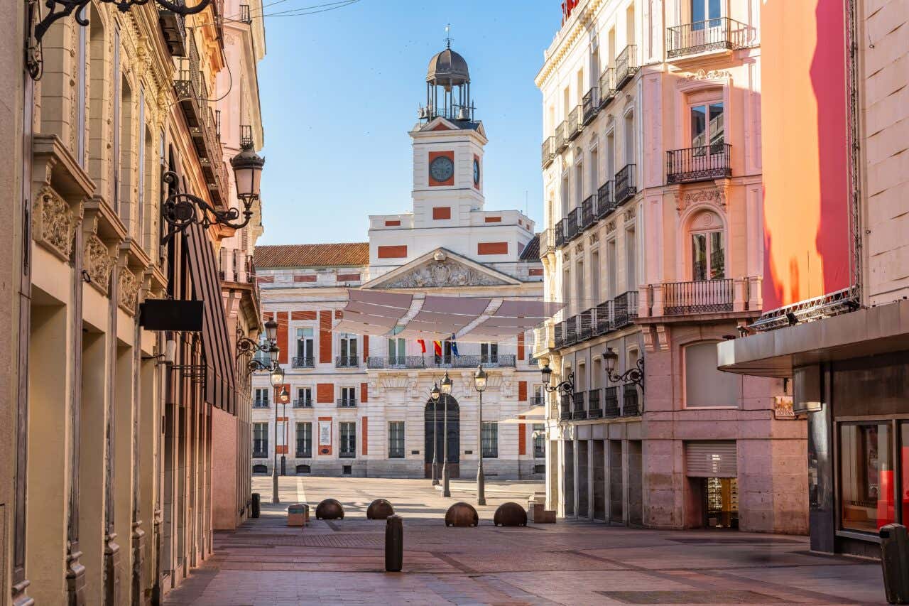 The town hall of the Puerta del Sol seen from a connecting street in Madrid with a clear blue sky.