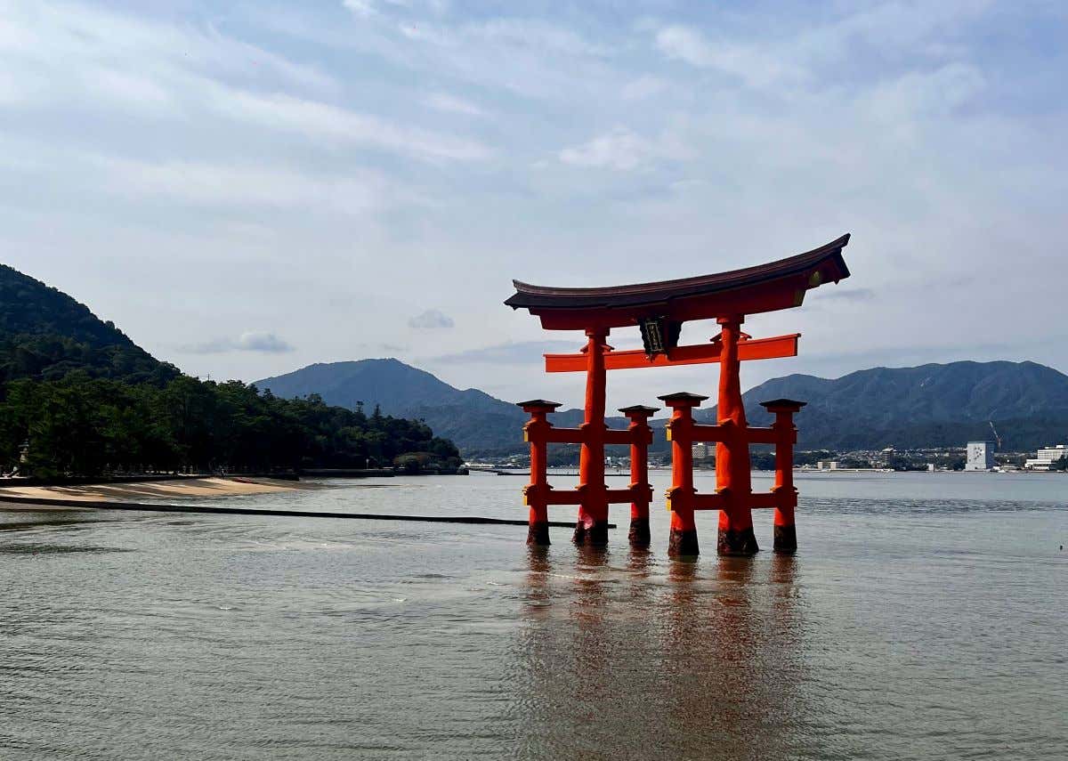 Panorámica del gran torii de Miyajima con las vistas del mar y montañas de fondo 