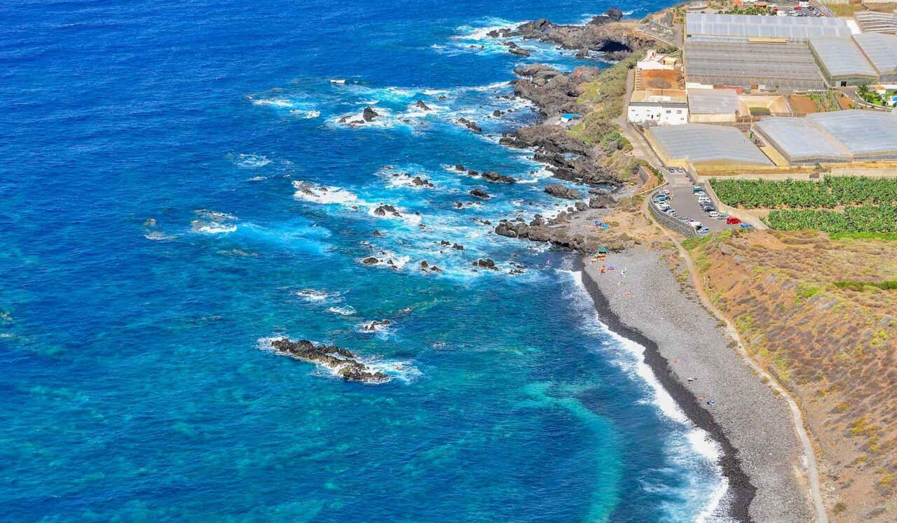 Vista panorámica de una playa de arena oscura en Tenerife.
