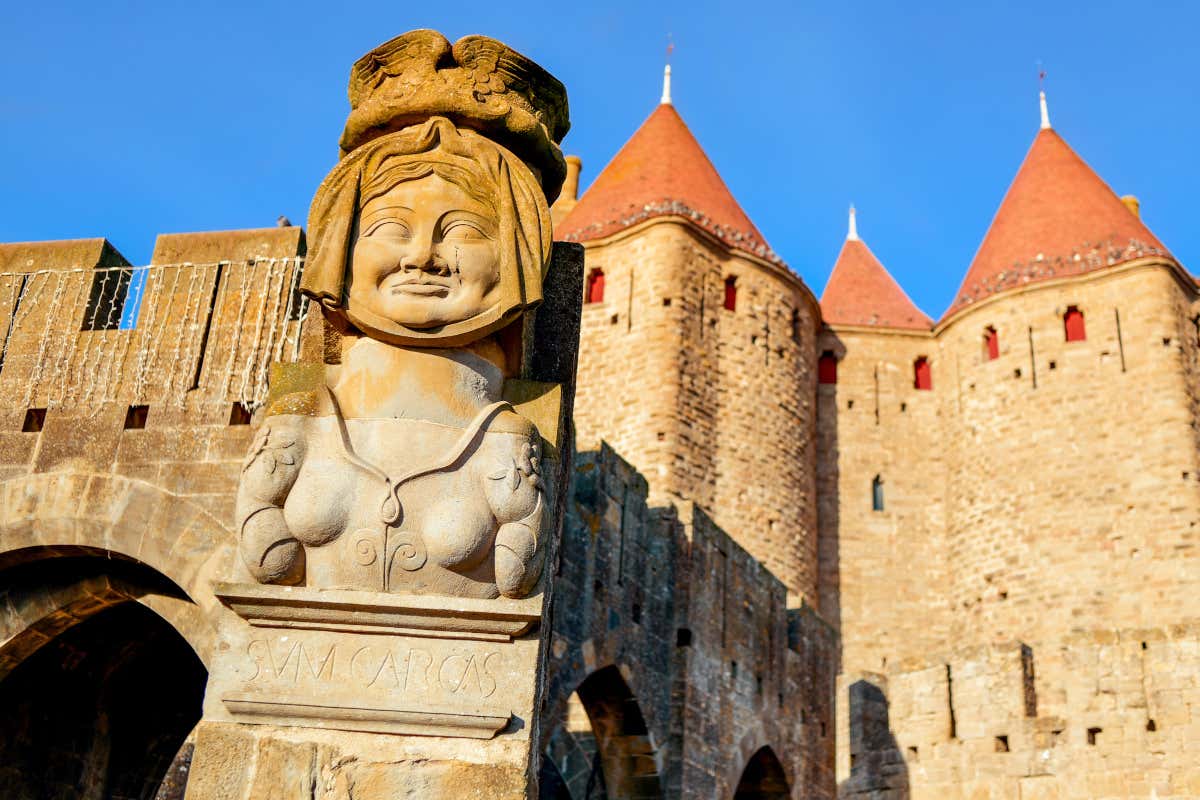 Busto en piedra de la dama Carcas presidiendo la entrada a la Puerta de Narbona, uno de los monumentos que hay que ver en Carcassonne