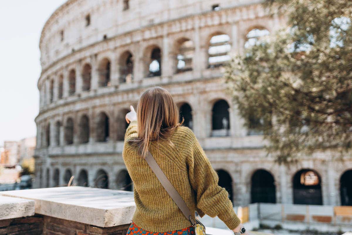 Una ragazza di spalle indica il Colosseo