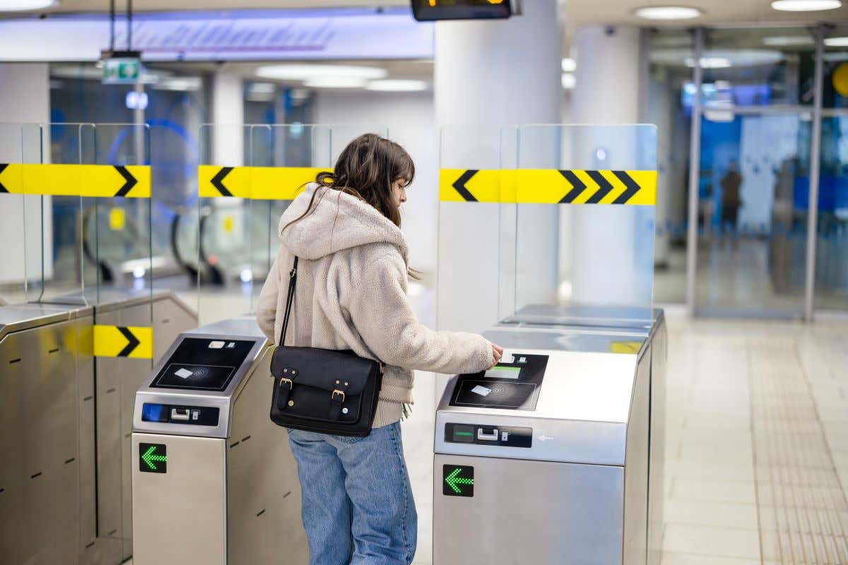 Chica pasando un torno de un tren en una estación japonesa