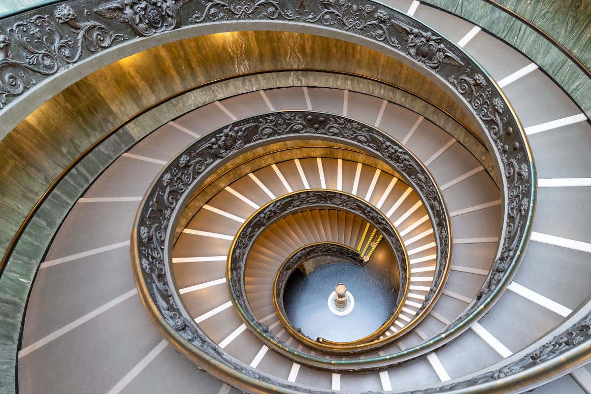 Una gran escalera de caracol de barandillas ornamentadas en el interior de un edificio