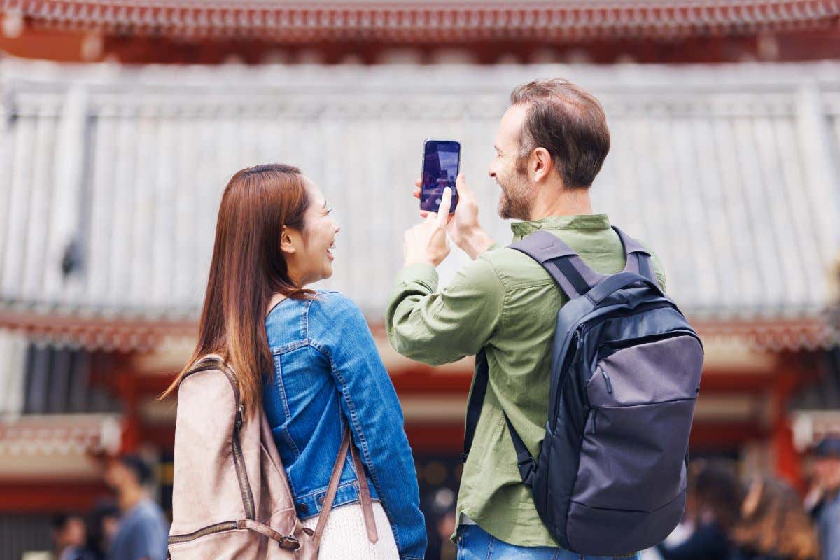 Dos turistas haciendo una foto a un monumento en Japón