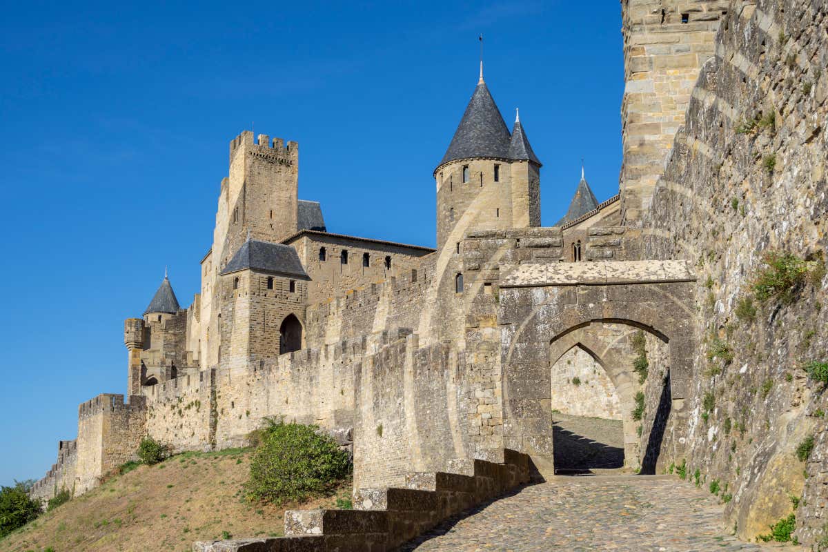 Detalle de la puerta de una muralla medieval, con unas torres de fondo
