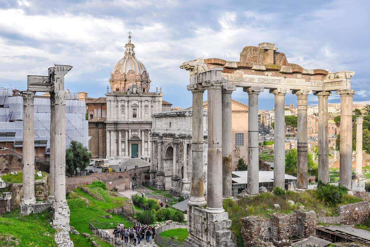 Ruinas del Foro Romano en Roma, con columnas antiguas y restos del templo en un día nublado.