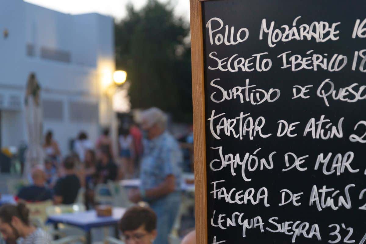 Detalle de una pizarra donde están escritos varios nombres de platos de comida
