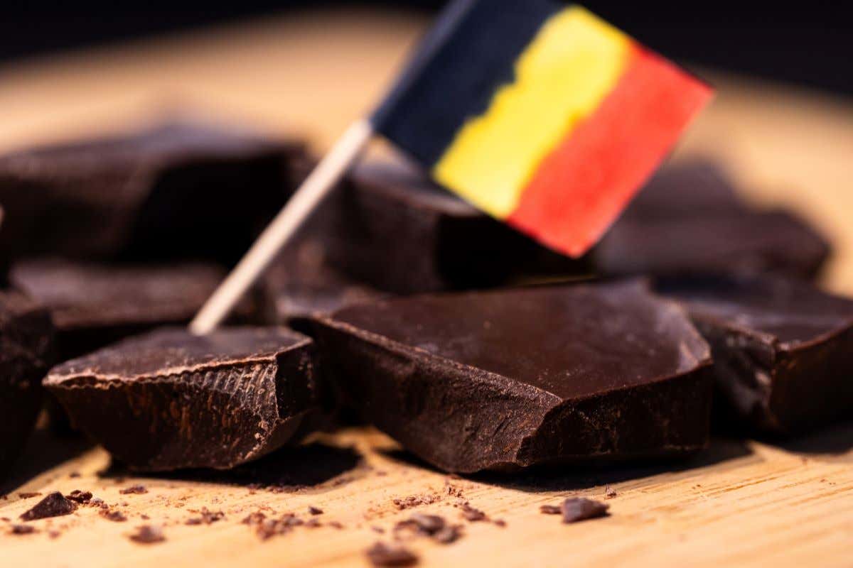 Detalle de unos trozos de chocolate belga con una banderita belga encima
