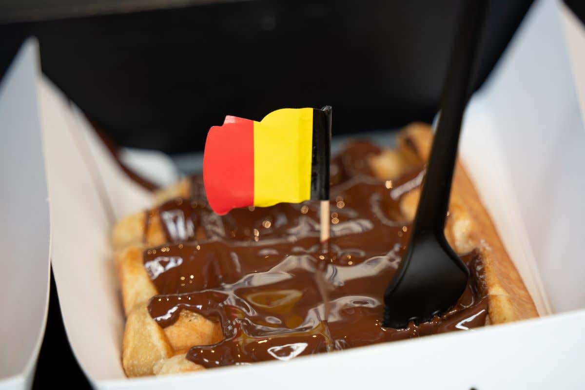 Detalle de un plato con un gofre belga y una banderita