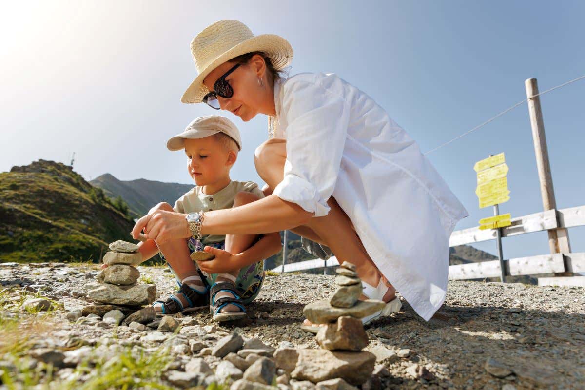 Niño con su madre jugando con unas piedras
