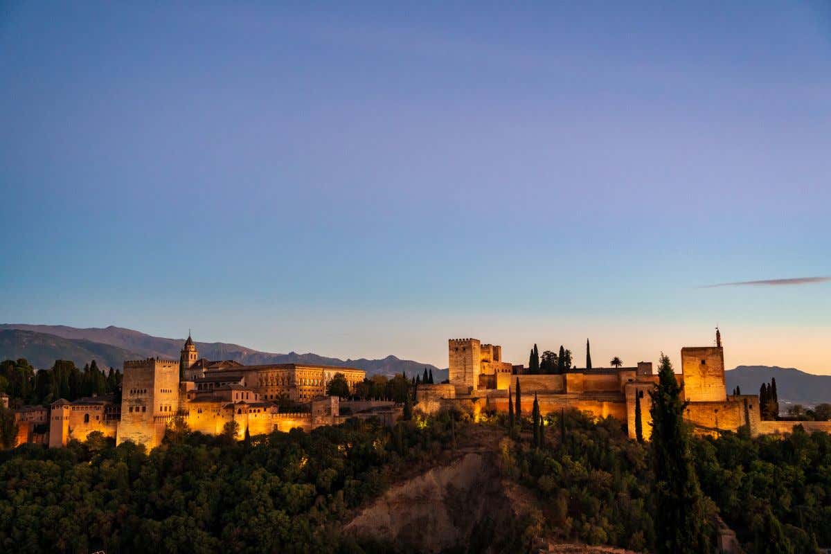Atardece sobre la Alhambra de Granada iluminada con tonos cálidos