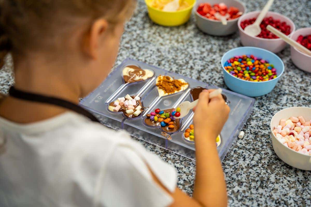Niña aprendiendo a hacer paletas de chocolate en el Choco Story de Bruselas