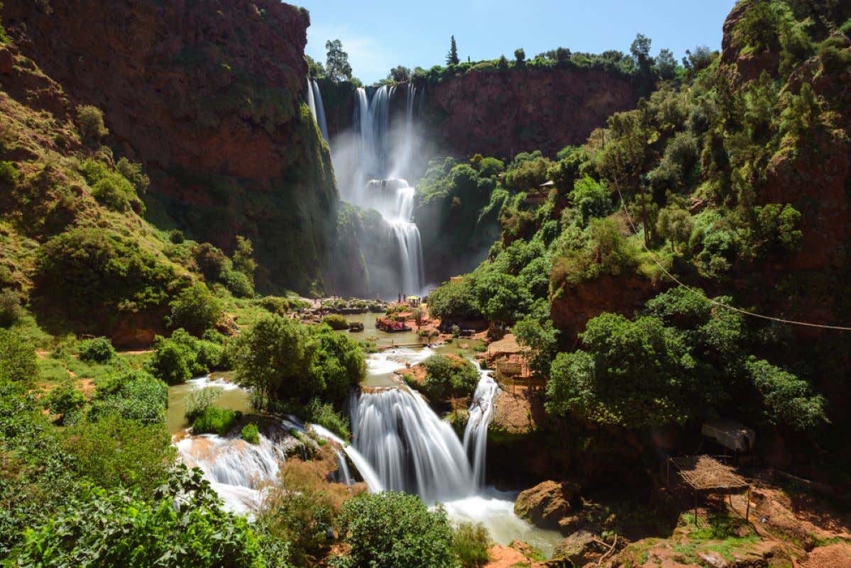 Views of the Ouzoud Waterfalls and vegetation on a sunny day.